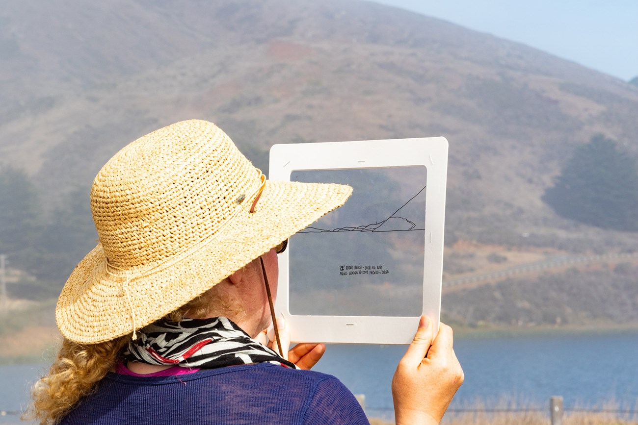A San Francisco State University student uses a Magic Window transparency to find evidence of geologic change in the environment at Rodeo Beach in the Marin Headlands