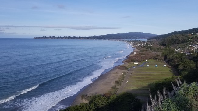An view of Stinson Beach from an overview, looking north. The photo is taken at a high King Tide, with very little beach available.
