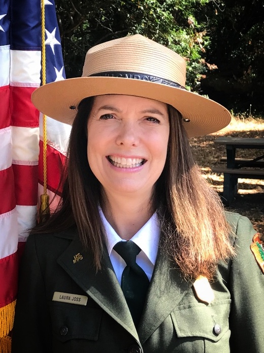 woman with green hat and uniform smiling