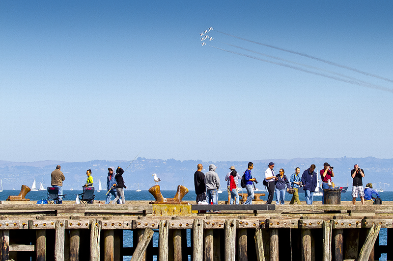 people on a pier during an air show