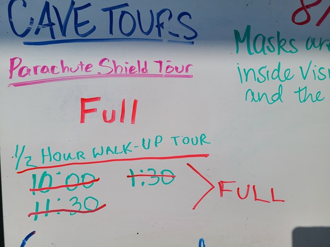 Whiteboard with text indicating full cave tours