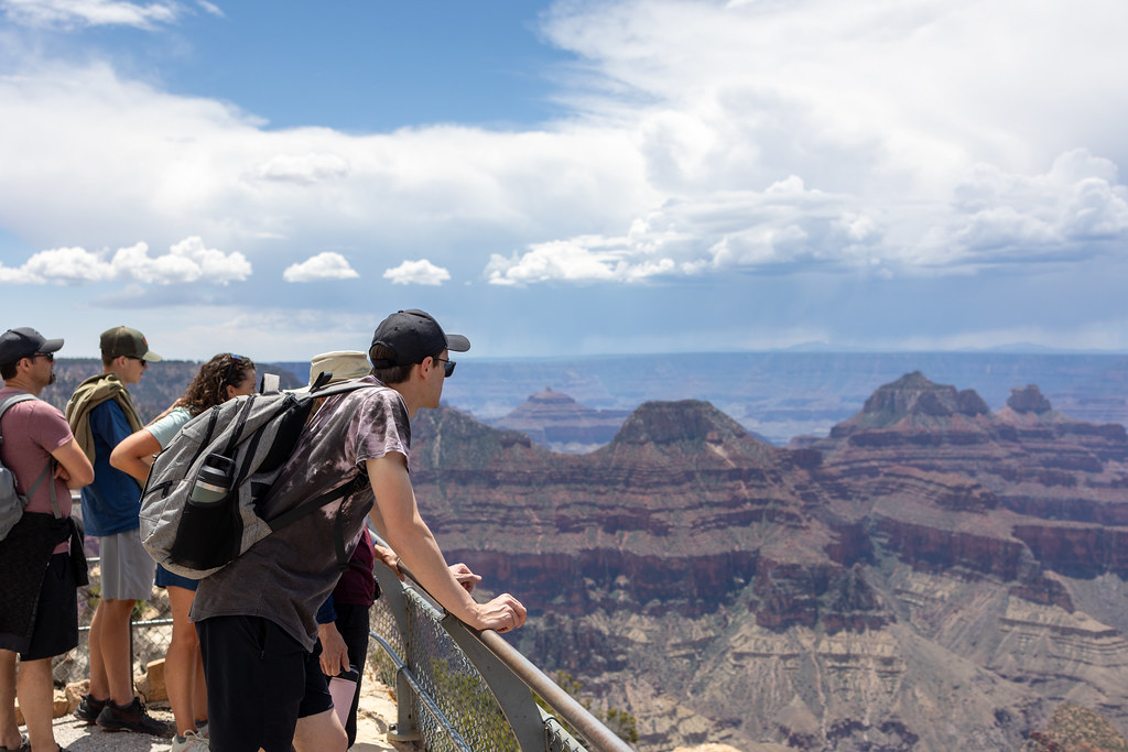 A group of young adults view the canyon landscape from Bright Angel Point