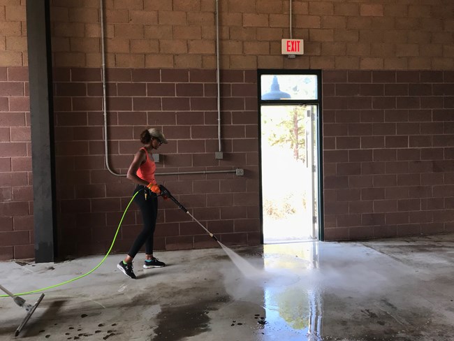 Student power washing a maintenance bay. Student power washing a maintenance bay.