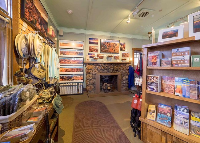 Merchandise-hanging-on-walls-and-books-on-shelves-with-fireplace-art-in-Kolb-Studio-Gift-Shop