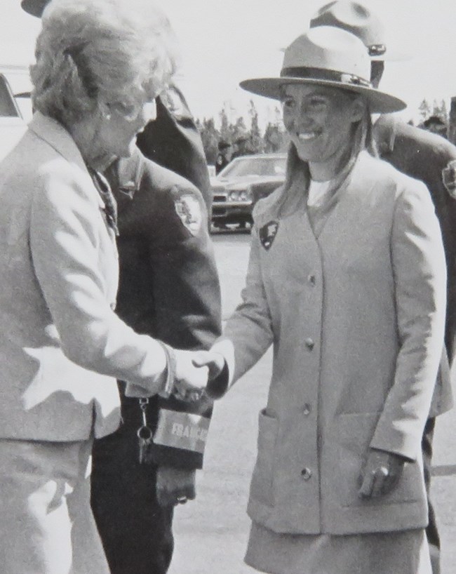 Female ranger in uniform smiling and shaking hands with Pat Nixon in Yellowstone National Park