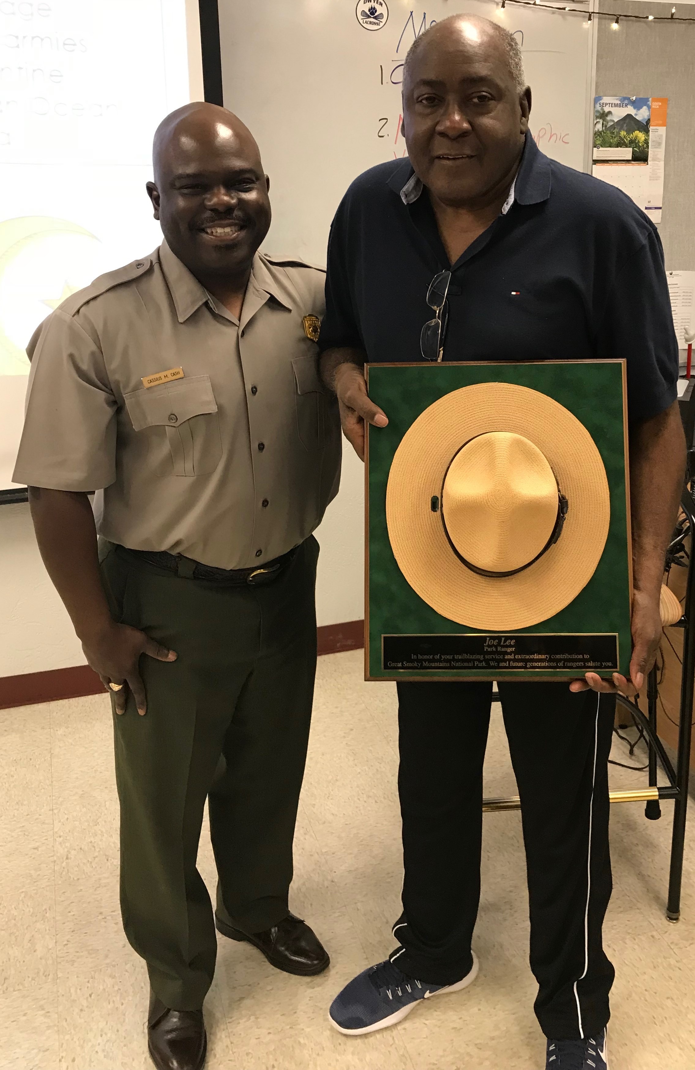 Superintendent Cash with Dr. Lee holding mounted ranger hat.