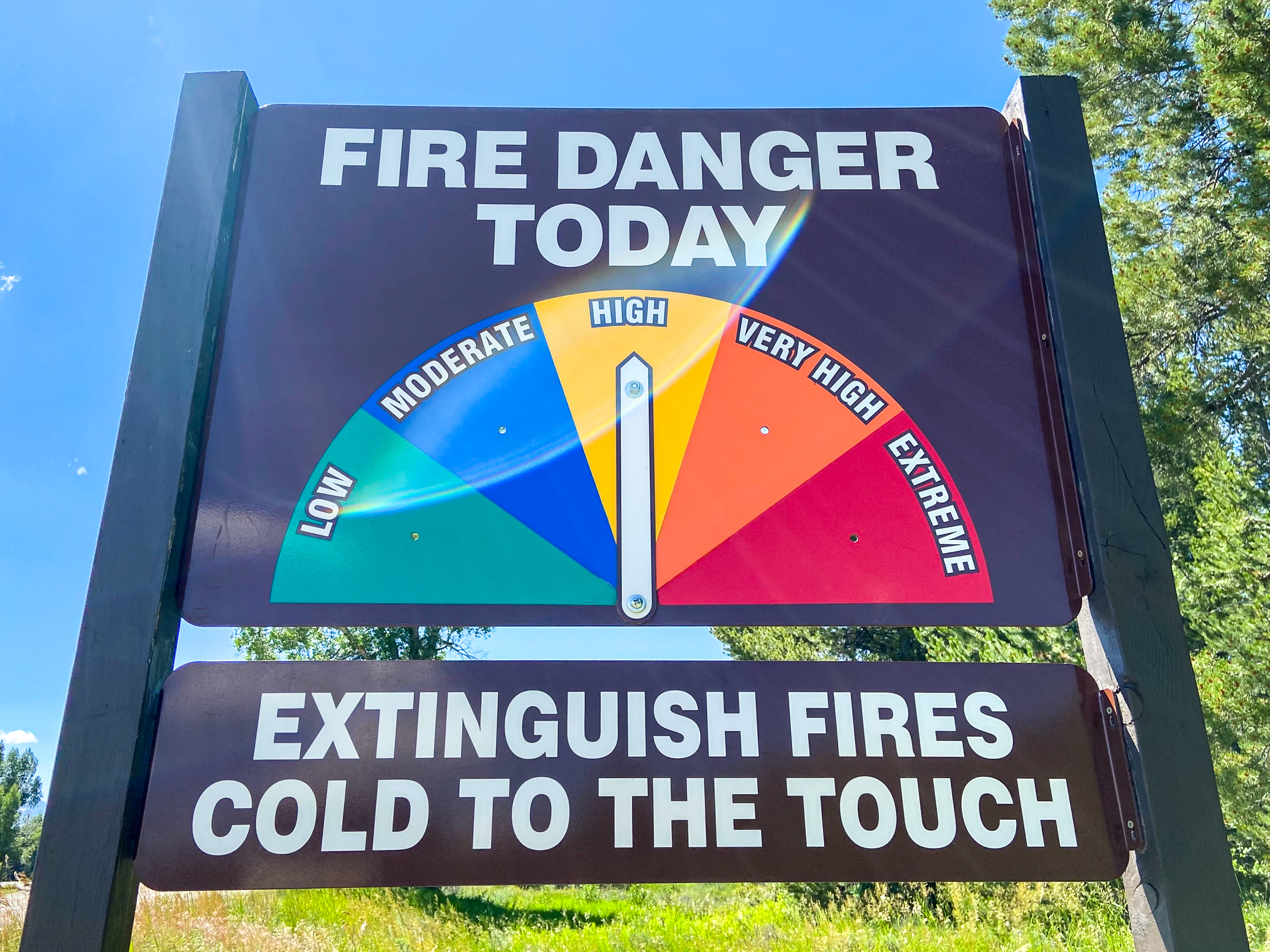 Sign that reads, "Fire Danger Today," with an arrow pointing to "High" and a message below that says, "Extinguish Fires Cold to the Touch"