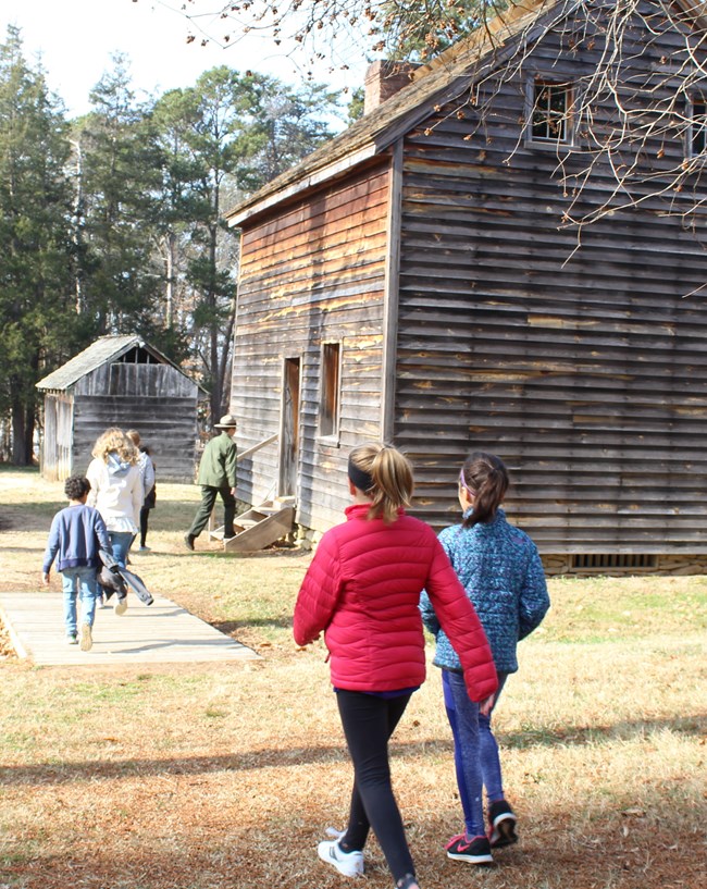 Park Ranger leads students into a clapboard house