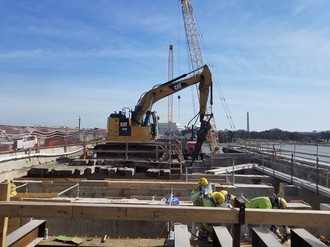 Construction machinery and workers on Arlington Memorial Bridge during rehabilitation project.