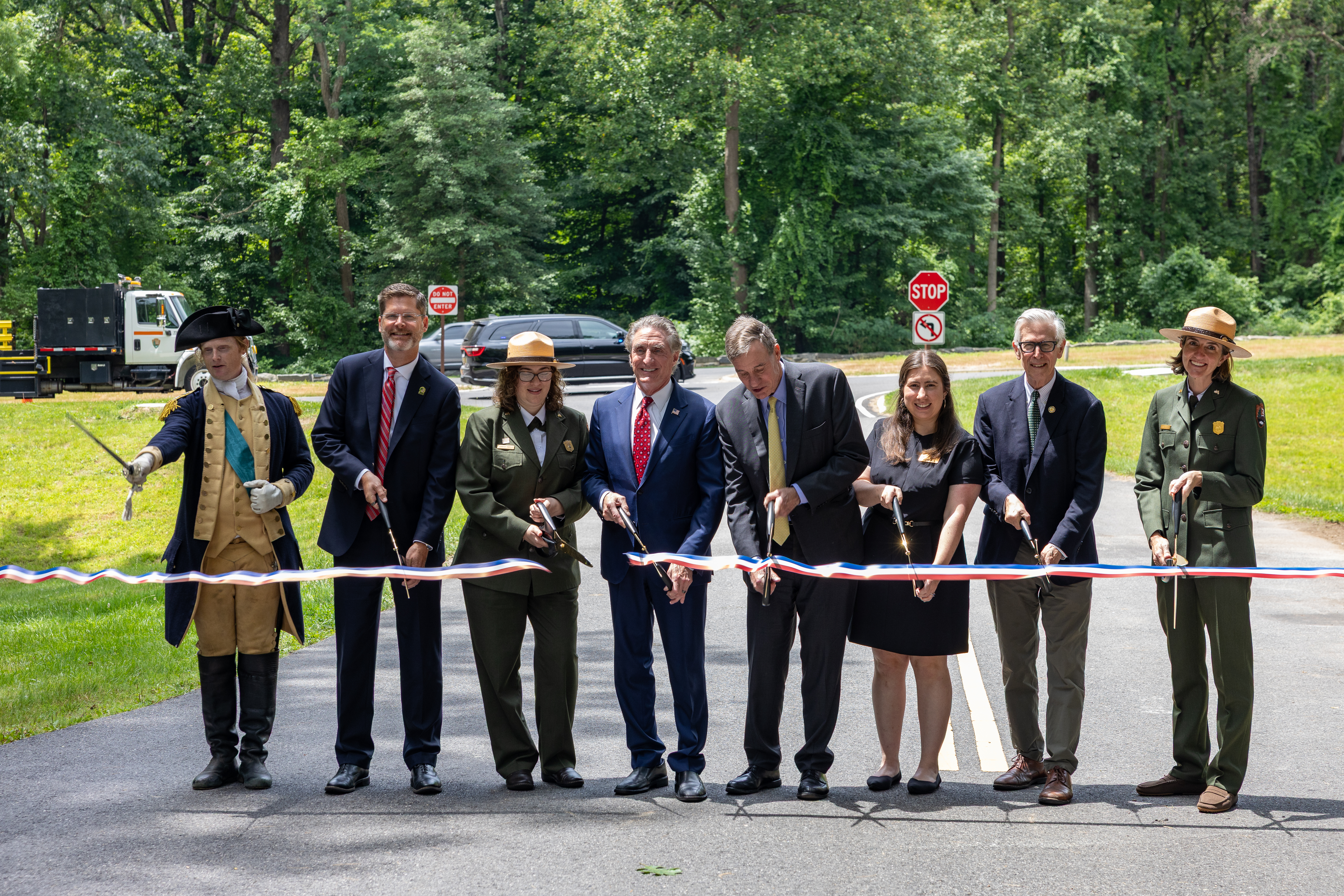 A group of officials cut a ribbon on a parkway.