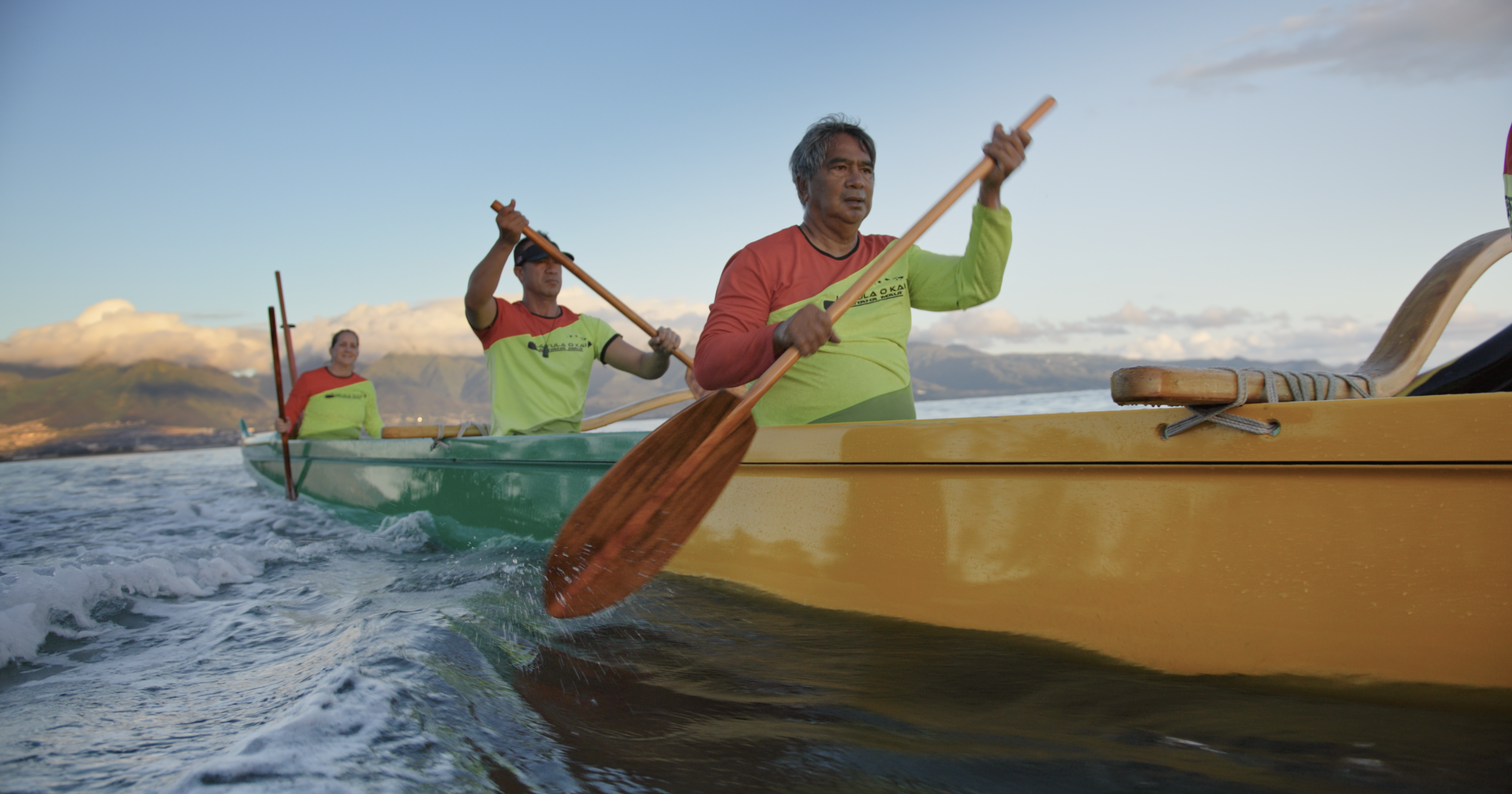 3 people in a canoe paddle through the water