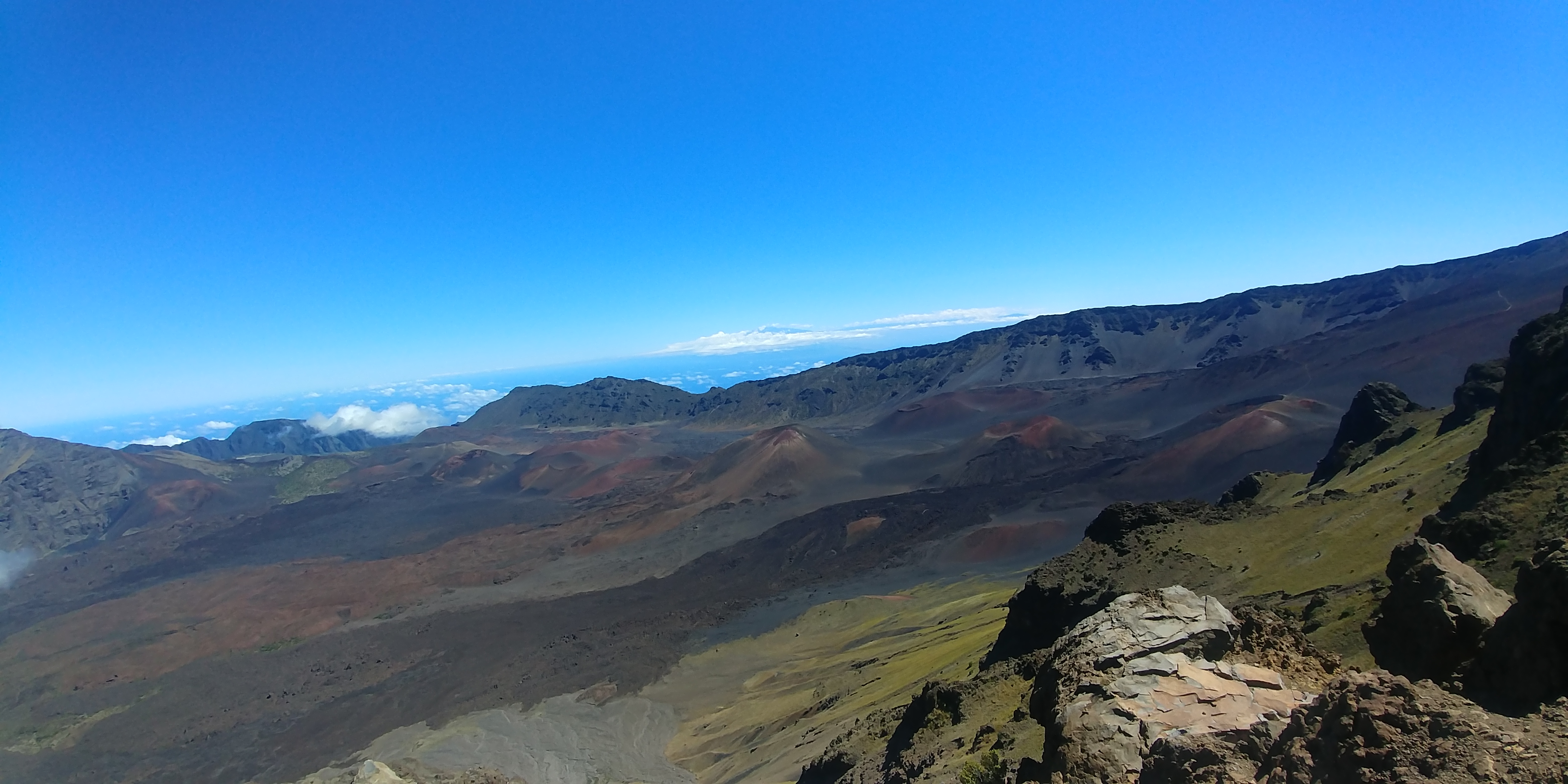 Volcanic landscape with blue sky and Hawaiʻi island in the background