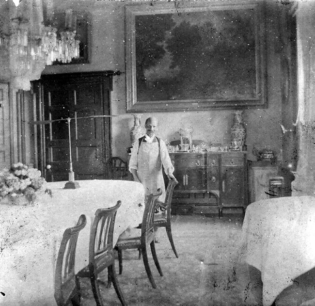 Photograph of Thomas Brown in the dining room inside of the Hampton mansion, c. 1895, NPS