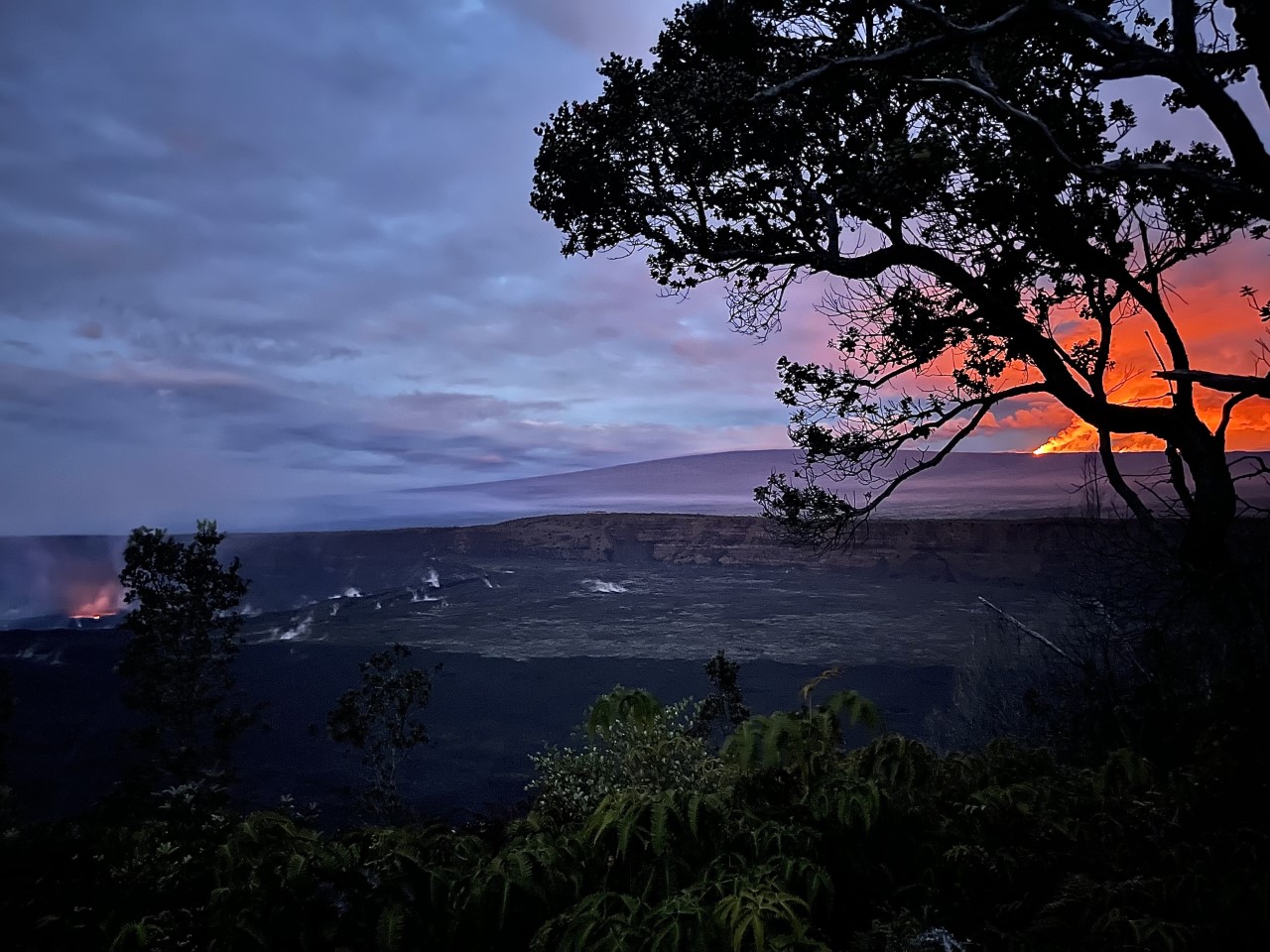 Two volcanoes erupt and lava reflects into the pre-dawn sky