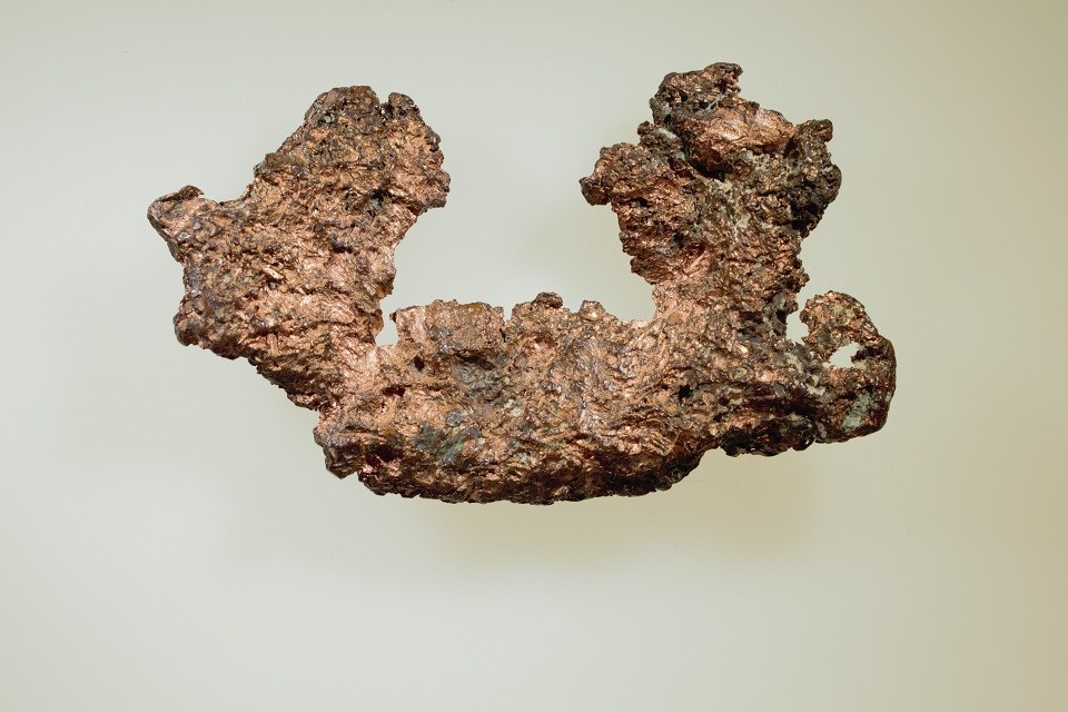 shiny, brown-colored metal chunk with pitted surface.