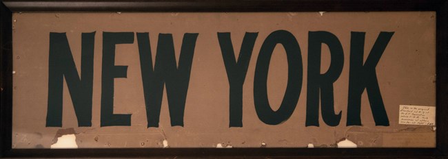 A framed paper sign with the words "NEW YORK"