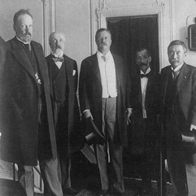 Four men in formal dress in standing pose for a camera.