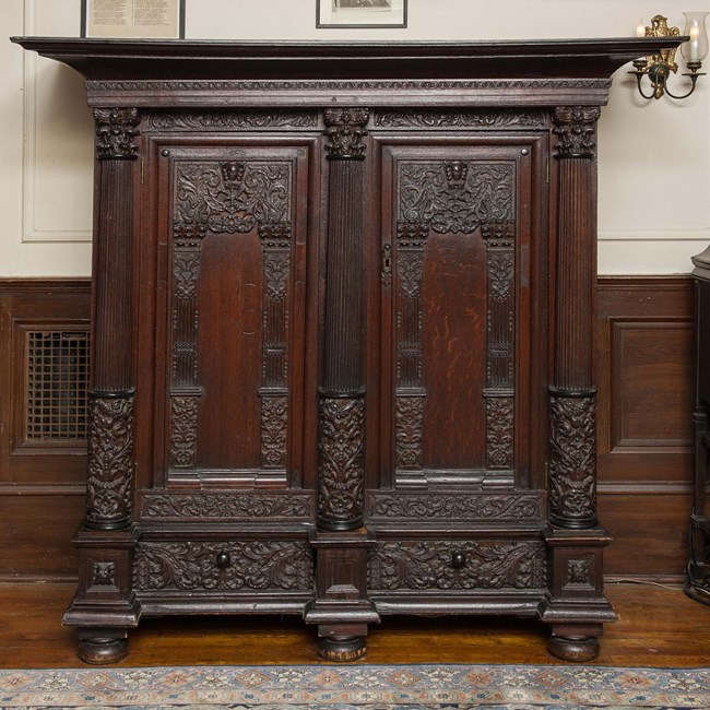 A large wood cabinet with double doors and deep carving.