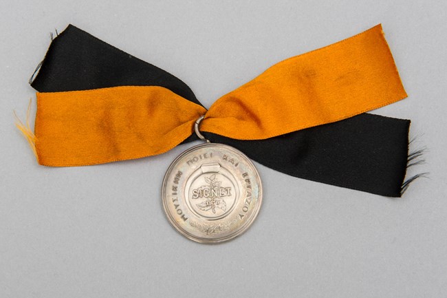 A round silver medal with silk ribbons