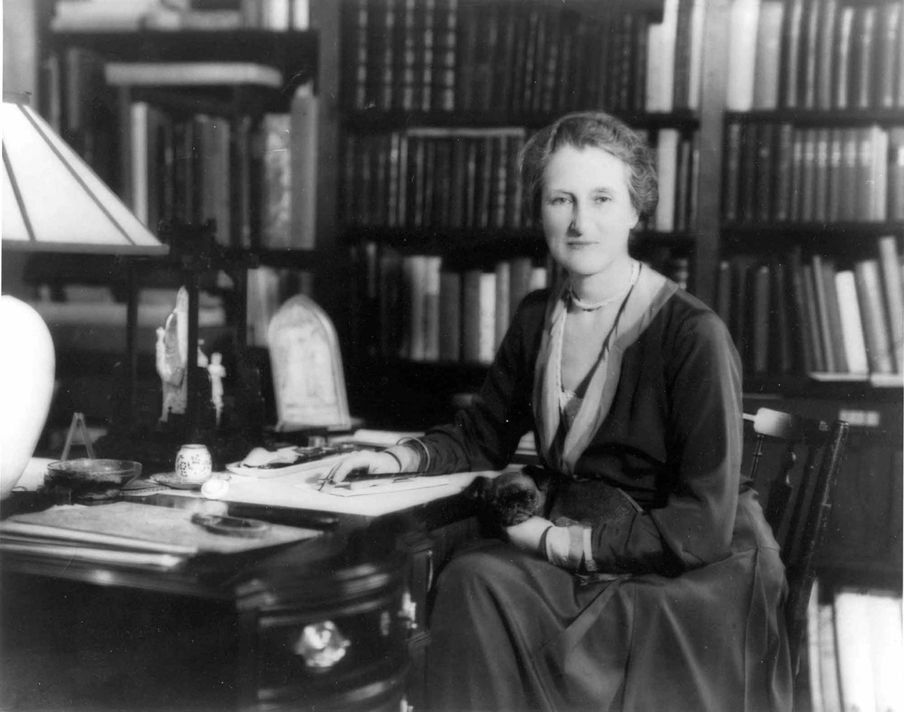 A photograph of Beatrix Farrand seated at a desk.