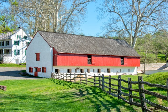 White and red barn with fence in foreground