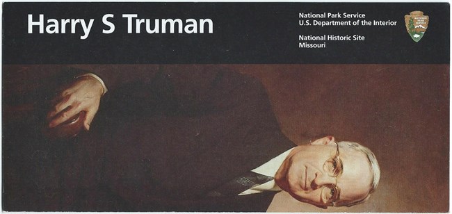 The front cover of the main park brochure, with a black band, the Park Service Arrowhead, and a painting of President Harry S Truman, with the park's name.