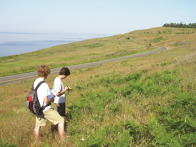 Two crew members using GPS to navigate a transect in the prairie