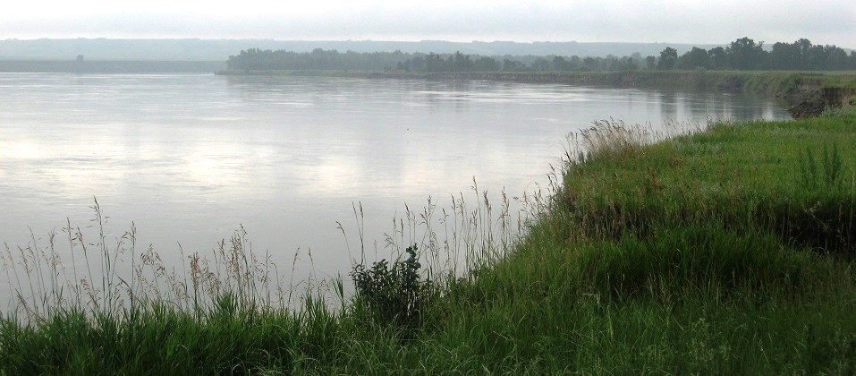 wide river on a cloudy day with grassy bank in the forground wide river on a cloudy day with grassy bank in the forground