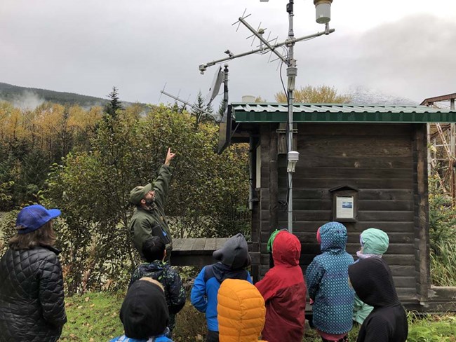 A group of kids learn about weather stations.