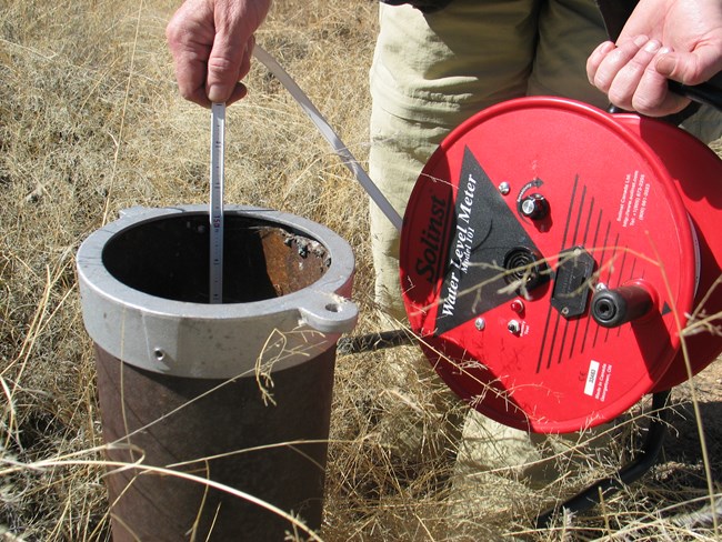 Groundwater well with measuring tape for water elevation