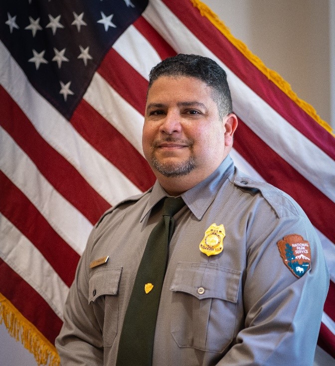 Adrian Fernandez in NPS uniform with US Flag in background