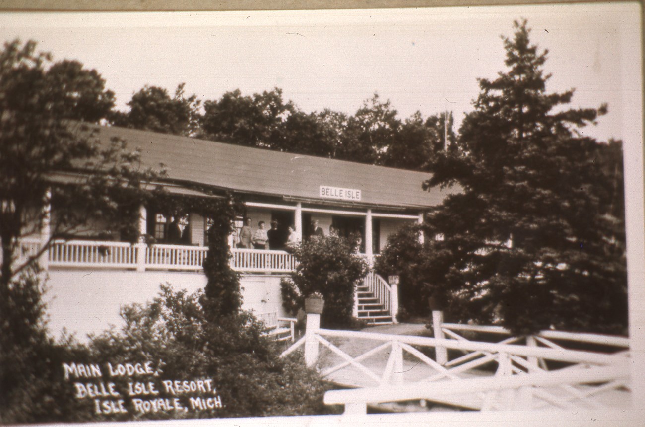 A historic image of the Belle Isle resort with people on the deck of the resort.