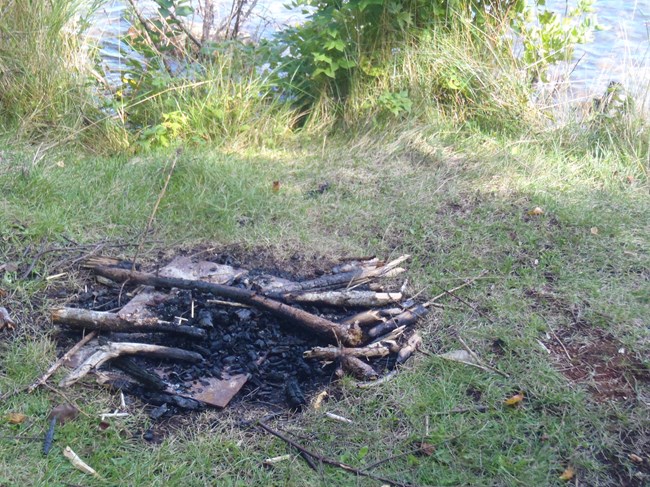 An illegal campfire in the ground at a campground.