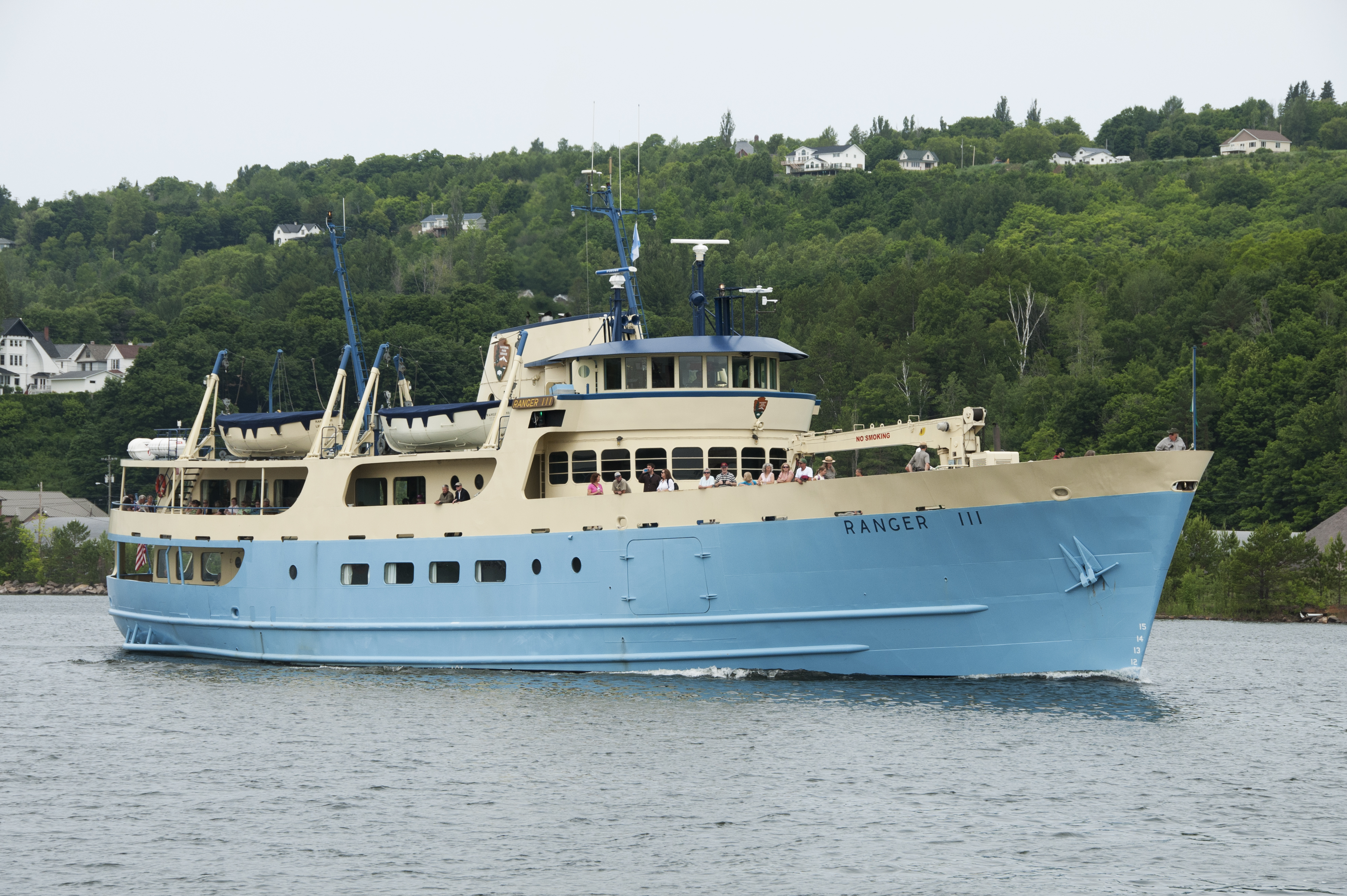 A large blue and yellow ferry sailing on a canal.