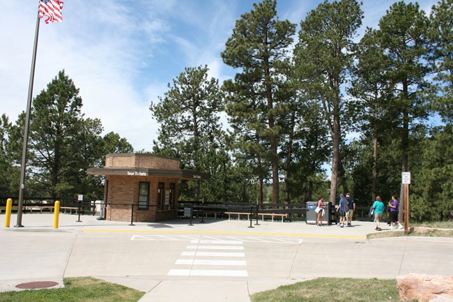A passenger drop off area along a roadway and a gazebo shaped building