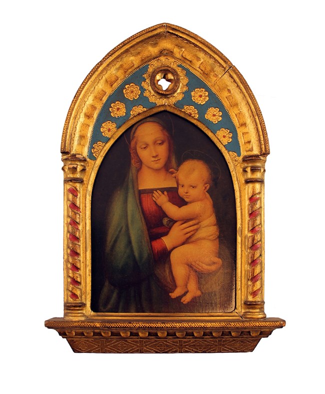 A painting in a rectangular wood frame with a pointed arch. The Virgin Mary, in a red dress and blue robe, holds infant Jesus. Both have halos. The frame is carved like cathedral pillars and ceiling, painted in gold leaf.