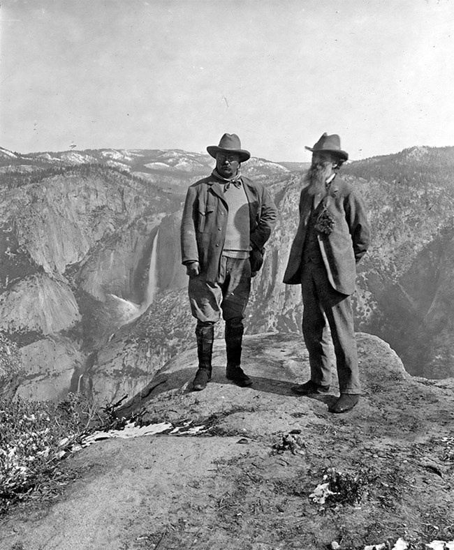 John Muir and President Roosevelt standing on a mountain at Yosemite.
