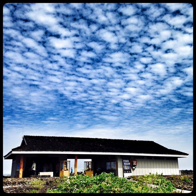 Picture of the Parkʻs contact station with blue sky and white cloudes