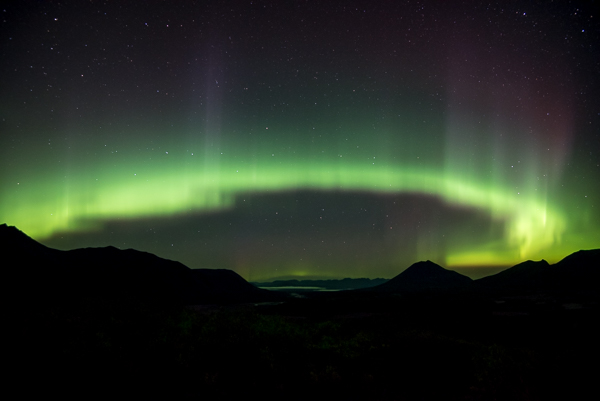 Green Aurora Lights over Silhouetted Mountains 