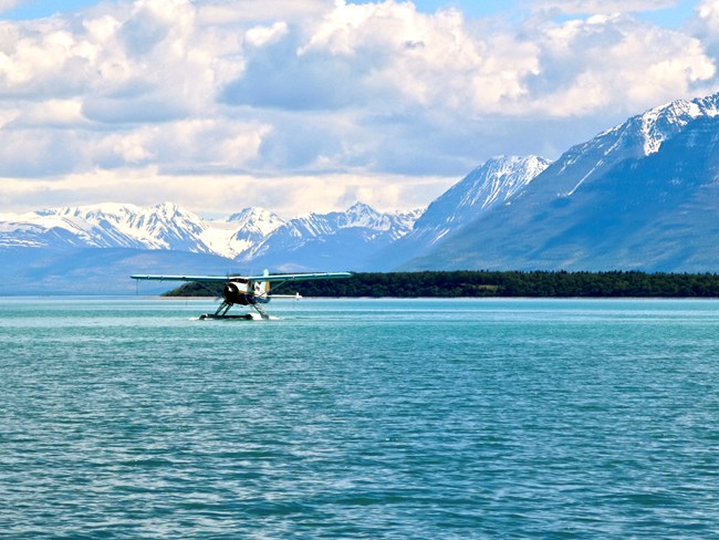 A float plane on water with mountains in the background
