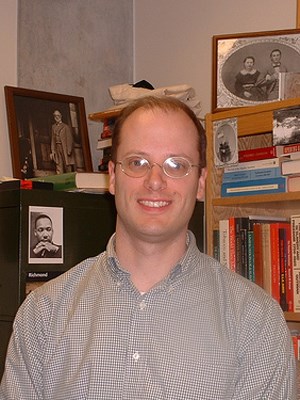 Man wearing glasses smiling.