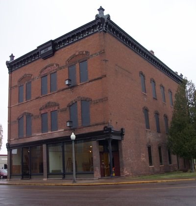 The exterior of a three story brick building with large windows on the first floor.