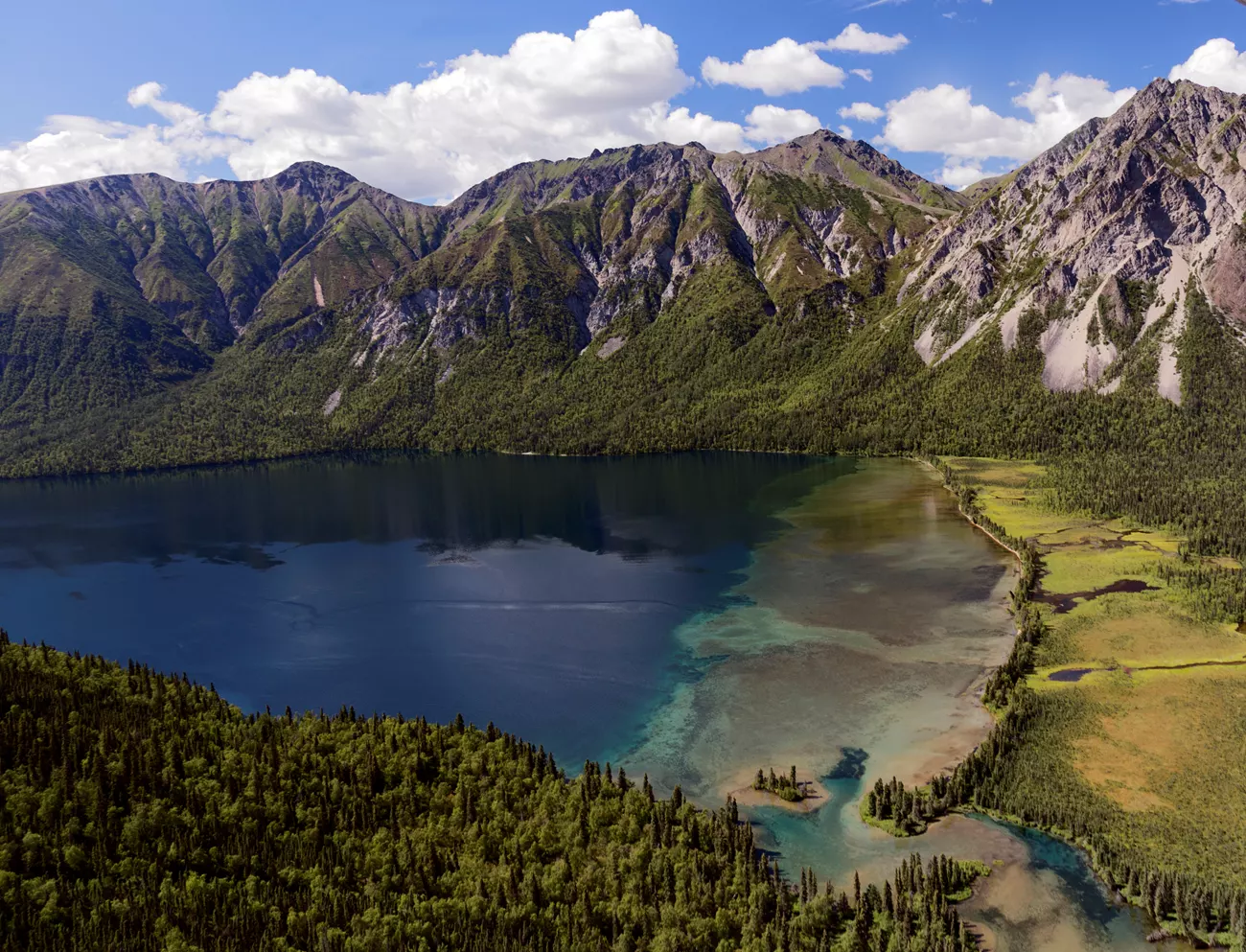 verdant mountains surround a deep blue lake.