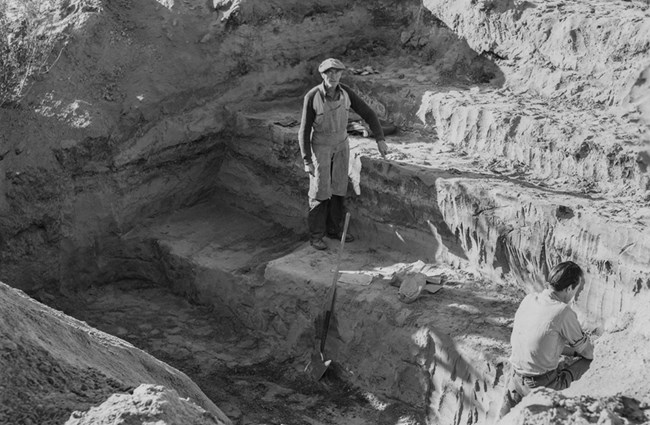 Men standing in excavation site