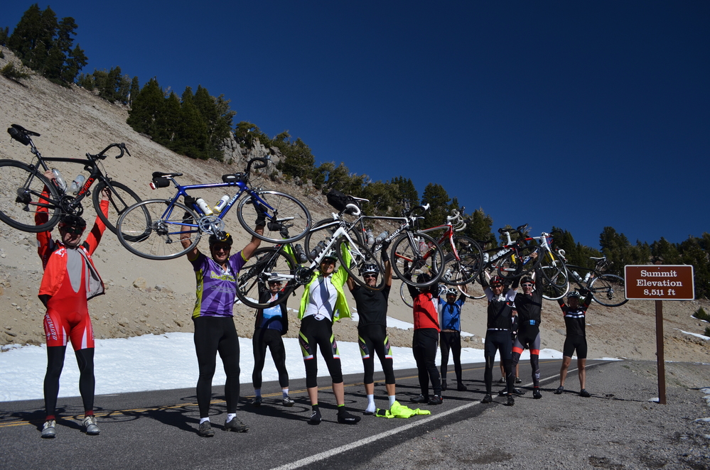 A group of bicyclists holding their bikes up on the park road