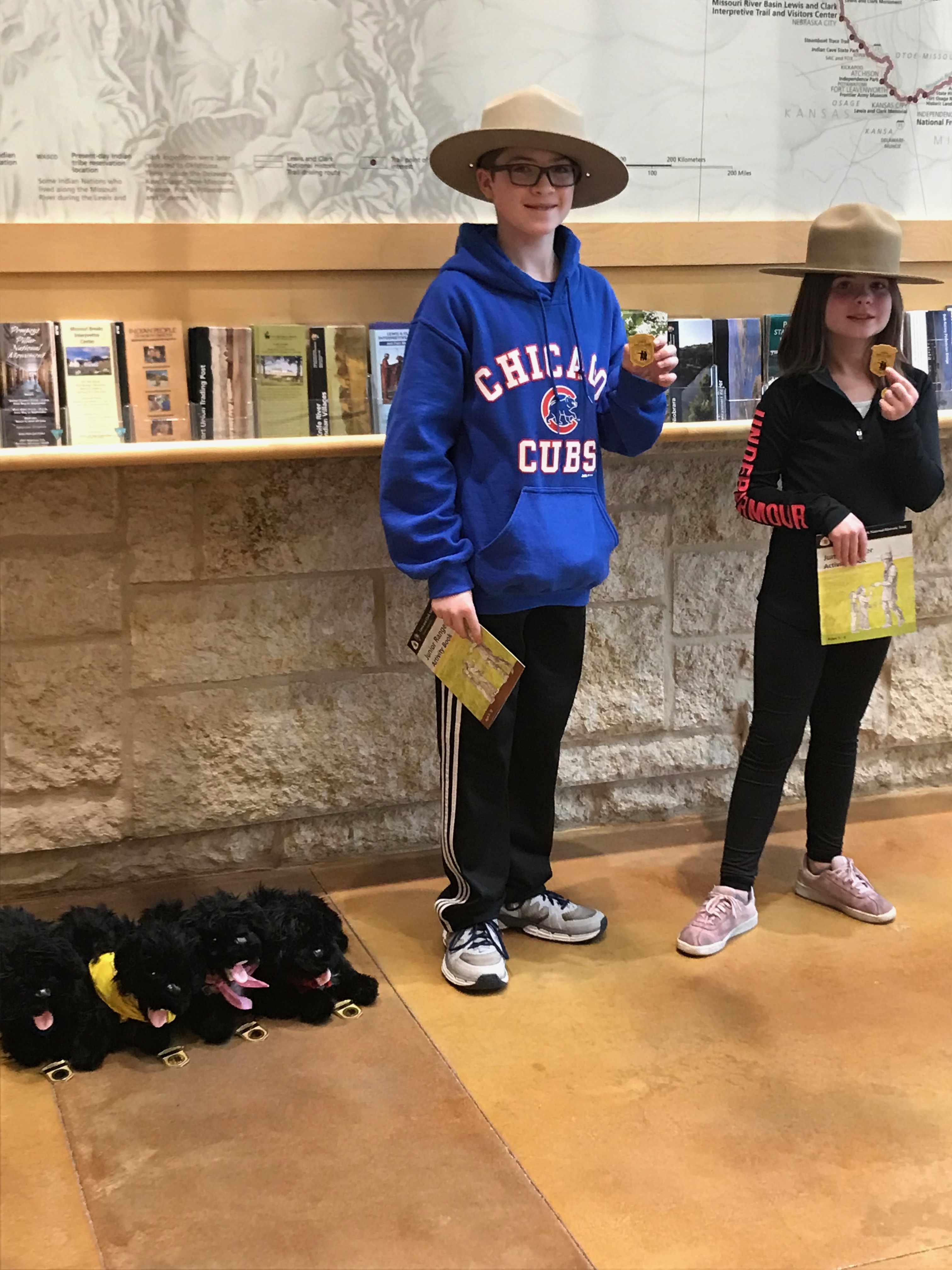 Two children and four pups show off their junior ranger badgers