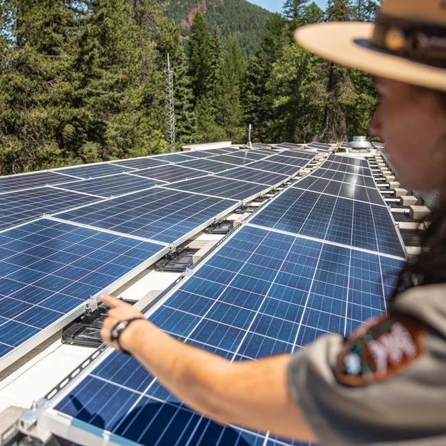 A NPS ranger points to a solar panel