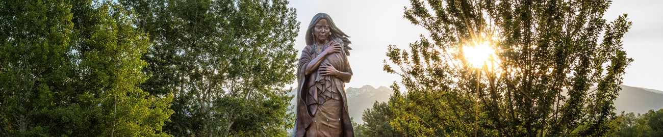 A statue of a woman, Sacagawea, holding a baby.