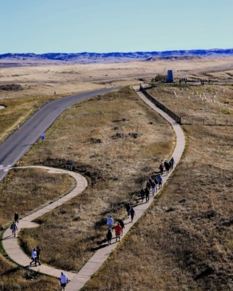 People walk up the trail to Last Stand Hill