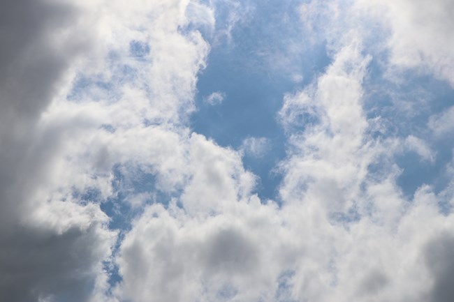 Fluffy white clouds and a clear, light blue sky.